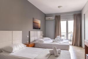 a hotel room with two beds and a window at Atrium Hotel in Leptokarya +59 photos