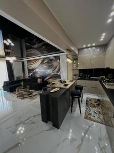 CSO Luxury Residence في مامايا: مطبخ وغرفة معيشة مع طاولة وكراسي