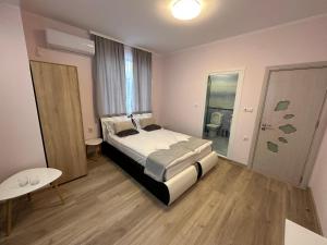 a bedroom with a large bed in a room with a table at Utopia Apartment 1, by LMG in Hisarya