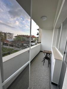 a balcony with a table and a view of a city at Utopia Apartment 1, by LMG in Hisarya