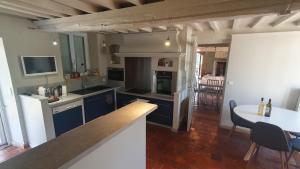 una cocina con armarios azules y una mesa en una habitación en Villa du Bonheur - 10 pers. - Spa - Sauna - Hammam 