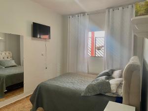 Schlafzimmer mit einem Bett und einem Fenster in der Unterkunft Casa com vista para o por do sol in São Thomé das Letras