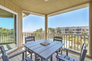 a porch with a table and chairs on a balcony at Port O' Call E302 - Top Floor Ocean View Condo! in Isle of Palms