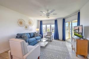 a living room with a blue couch and a tv at Port O' Call E302 - Top Floor Ocean View Condo! in Isle of Palms