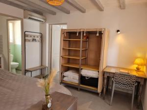a room with a desk and a bed and a desk and a desk at appart cosy avec son exterieur chaleureux,piscine et parking prive in Fontvieille