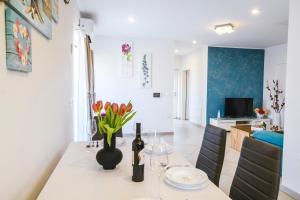 a kitchen and dining room with a table with a vase of flowers on it at Apartments Mirela in Koper