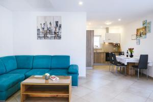 a living room with a blue couch and a table at Apartments Mirela in Koper