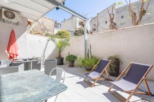 d'une terrasse avec une table, des chaises et une clôture. dans l'établissement La Piazzetta - Terrasse au calme, à Marseille