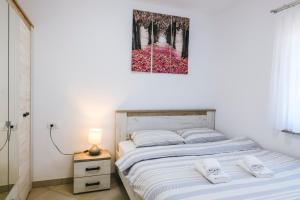 a bedroom with a bed and a painting on the wall at Apartments Mirela in Koper