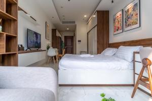 a bedroom with a large white bed and a kitchen at De Lux Central Studio next Hyatt ,Opera House ,Benthanh ,Pool,Gym in Ho Chi Minh City