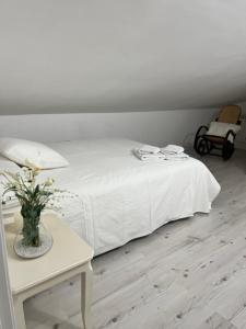 a bedroom with a white bed with a table and a chair at Villa Trap in Guadalix de la Sierra