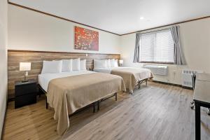 um quarto de hotel com duas camas e uma janela em Highbridge Hotel em Bronx