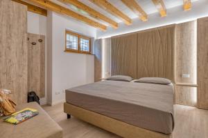 1 dormitorio con 1 cama grande y techo de madera en Concilium en Trento