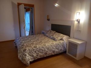 ein kleines Schlafzimmer mit einem Bett und einem Nachttisch in der Unterkunft Casa Mariñao 1 in Loiba