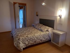 a small bedroom with a bed and a night stand at Casa Mariñao 1 in Loiba