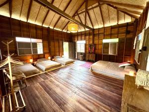 a bedroom with four beds in a wooden room at La Maison - Chiangmai in Mae Taeng