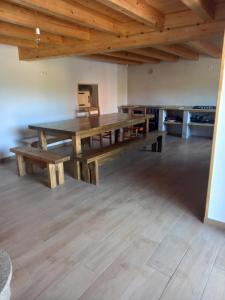 ein großes Esszimmer mit einem Holztisch und Bänken in der Unterkunft Casa Mariñao 1 in Loiba