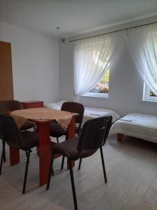 een kamer met een tafel en stoelen en een bed bij PRZYSTANEK nowEKOprzywno - Żółty Domek Pod Kasztanem in Barwice