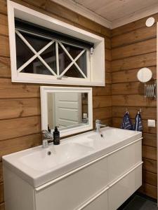 a bathroom with a white sink and a mirror at Stuga i Valfjället in Åmotsfors