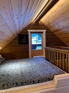 een slaapkamer met een bed in een houten huis bij Stuga i Valfjället in Åmotsfors