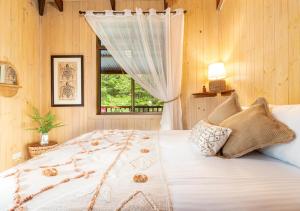 a bedroom with a large bed with a window at The Forest Buré - Fijian Hinterland Retreat in Ninderry