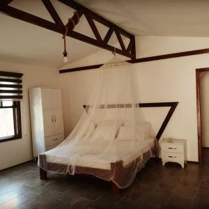 a bedroom with a bed with a mosquito net at Kidrak Camping NAMASTE in Faralya