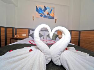 two white swansuitsrendered to look like hearts on a bed at Arges old city hotel in Istanbul