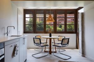 une cuisine avec une table et des chaises ainsi qu'une fenêtre dans l'établissement Canvas Apartments & Lofts Girona, à Gérone