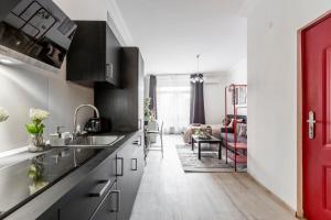 a kitchen with a sink and a red door at Deluxe Quentin Apartment next to the Synagogue in Budapest