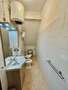 y baño con aseo, lavabo y espejo. en Casa Cencioni, en Tuscania