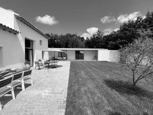a house with a patio and a yard with chairs at Casa do Carvalhal - Quinta do Soldado in Alquerubim