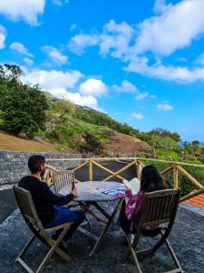 a man and a woman sitting at a table at Quinta do Caminho da Igreja TER-Casas de Campo in Velas