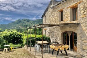 kamienny dom ze stołem i krzesłami na patio w obiekcie Gîte d'étape Bastide Petra Castellana Verdon w mieście Castellane