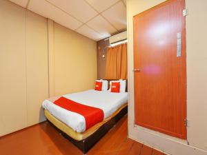 a small room with a bed and a door at OYO 90627 Pulau Ketam Inn in Klang