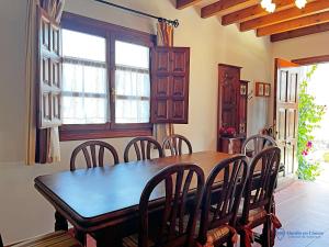 ein Esszimmer mit einem Holztisch und Stühlen in der Unterkunft Las Encinas adosado en Pechon in Pechón