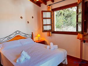 Schlafzimmer mit einem Bett mit weißer Bettwäsche und einem Fenster in der Unterkunft Las Encinas adosado en Pechon in Pechón