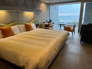 a large bed in a room with a large window at THE HOTEL YAKUSHIMA ocean & forest in Yakushima