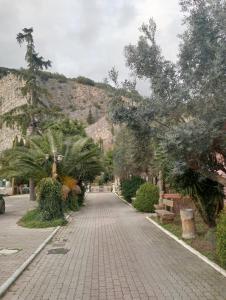 a brick walkway with trees and a mountain in the background at Baron'sRoom in Nocera Inferiore