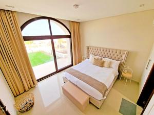 een slaapkamer met een bed en een groot raam bij Jebel Sifah Suites in As Sīfah
