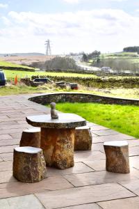 a stone table and two stools on a stone patio at The Coach House 