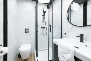 uma casa de banho com um chuveiro, um WC e um lavatório. em Prime Apartments - Oliva View em Gdansk