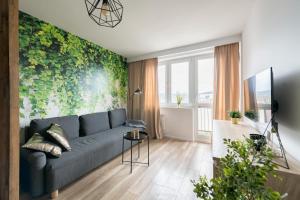uma sala de estar com um sofá azul e uma parede verde em Prime Apartments - Oliva View em Gdansk
