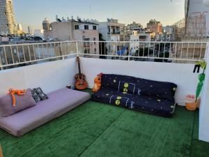 a balcony with a couch and a guitar on a building at Apartments BU93 in Tel Aviv