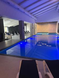 una gran piscina con iluminación azul en un edificio en BAYKA - SPA resort en Kosiv