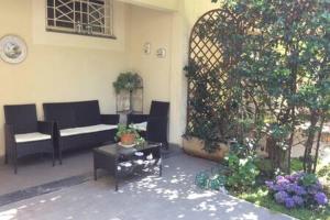 une terrasse avec un canapé, une table et un arbre dans l'établissement Residence Apuamare, à Pietrasanta
