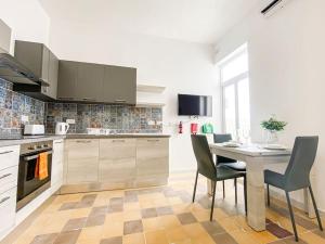 a kitchen with a table and chairs in a kitchen at Spacious 1 bedroom apartment in Gzira 5 in Il-Gżira