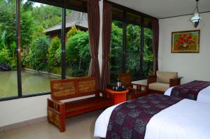 ein Schlafzimmer mit einem Bett und einem großen Fenster in der Unterkunft Amartya Puri Green Cottages in Munduk + 161 Fotos