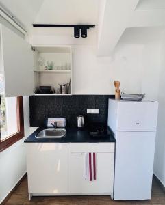 a white kitchen with a sink and a refrigerator at Vista House Marmaris in Marmaris