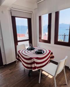 una sala da pranzo con tavolo, sedie e finestre di Vista House Marmaris a Marmaris