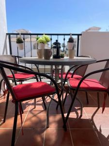 d'une table et de chaises sur un balcon orné de plantes. dans l'établissement La Ciñuelica R14 First Floor Apartment L126, à Orihuela